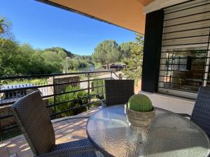 einen Glastisch und Stühle auf einem Balkon mit Aussicht in der Unterkunft Las Ondinas del Lago in Las Jaras