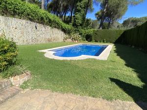 - une petite piscine dans une cour avec gazon dans l'établissement Las Ondinas del Lago, à Las Jaras