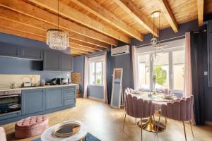 eine Küche mit einem Tisch und einem Esszimmer in der Unterkunft Rose & Blue Spa proche Chalon S/Saône et Beaune in Saint-Martin-en-Bresse