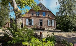 uma casa de tijolos com um telhado de gambrel em Haus zu den Büschen 02 em Wustrow