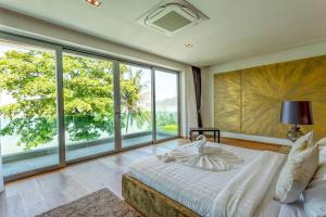 a bedroom with a large bed and large windows at Do You Want Luxury Sea views With Beach Access in Ban Saiyuan (1)