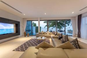 a living room with couches and a large screen television at Do You Want Luxury Sea views With Beach Access in Ban Saiyuan (1)