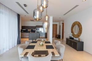 une salle à manger avec une table et des chaises blanches dans l'établissement Do You Want Luxury Sea views With Beach Access V38, à Ban Saiyuan (1)