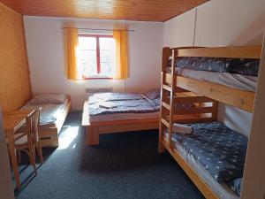 Zimmer mit 2 Etagenbetten und einem Tisch in der Unterkunft Chata Florian in Srní