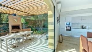 プラゼーレスにあるEden Sun - A Modern Luxury Villa with a Panoramic Viewのキッチン、ダイニングルーム(テーブル、暖炉付)