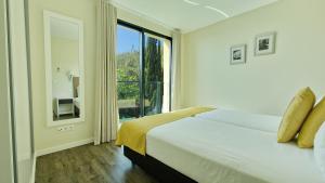 Un dormitorio con una cama y una ventana grande. en Eden Sun - A Modern Luxury Villa with a Panoramic View, en Prazeres 34 fotos más