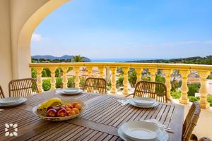 a table with a bowl of fruit on a balcony at Villa Perla by Abahana Villas in Teulada