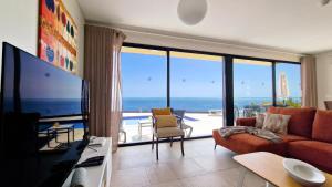 a living room with a view of the ocean at Eden Sun - A Modern Luxury Villa with a Panoramic View in Prazeres