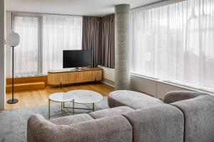 a living room with a couch and a tv at Karlin Residence by TKC in Prague