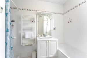 a white bathroom with a sink and a shower at Le Sully - Joli duplex centre de Nantes in Nantes +6 photos