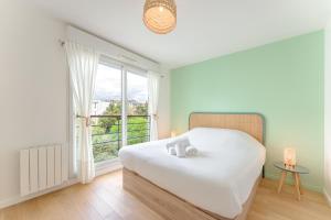 a bedroom with a white bed and a window at Le Sully - Joli duplex centre de Nantes in Nantes