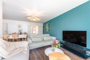a living room with a couch and a tv at Le Sully - Joli duplex centre de Nantes in Nantes