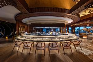 a lobby with a round bar with chairs around it at Anantara Mina Al Arab Ras Al Khaimah Resort in Ras al Khaimah