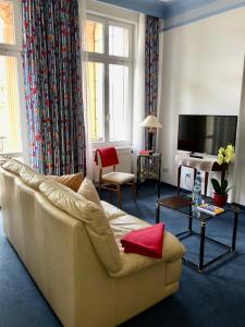 sala de estar con sofá blanco y TV en Hotel Villa Hentzel, en Weimar