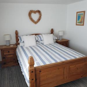 ニューキーにあるChynoweth Mewsのベッドルーム1室(壁にハートを配置した木製ベッド1台付)