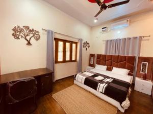 1 dormitorio con cama, escritorio y ventana en Stayble Homestay en Dehradun