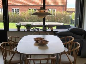 a white table and chairs with a bowl on it at Funen Cottage With Fantastic Sea View, in Assens