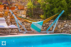 two hammocks sitting next to a swimming pool at Villa Paradise by Abahana Villas in Calpe