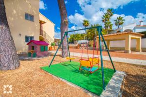 a swing set in a yard next to a house at Villa Paula by Abahana Villas in Benissa