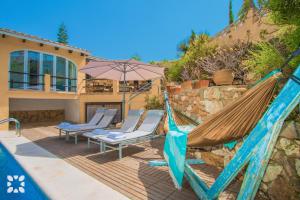 a hammock and chairs on a deck next to a house at Villa Paradise by Abahana Villas in Calpe