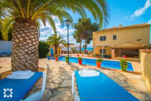 un complejo con una piscina y una palmera en Villa Paula by Abahana Villas, en Benissa