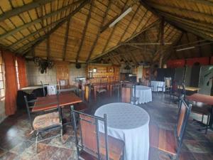 un comedor con mesas y sillas en un edificio en Linglela Lodge, en Estcourt