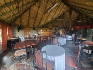 a dining room with tables and chairs in a building at Linglela Lodge in Estcourt