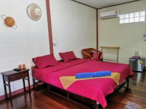 um quarto com uma cama grande com lençóis vermelhos e azuis em Chanida home em Phra Nakhon Si Ayutthaya