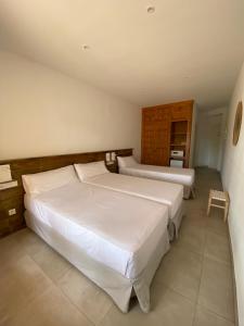 a bedroom with two beds in a room at Hostal Palmaria in Cala Santanyi