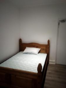 a bedroom with a wooden bed with a white pillow at Happy home in Brimington