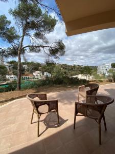 two chairs and a table on a patio at Hostal Palmaria in Cala Santanyi