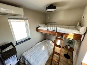 two bunk beds in a small room with a window at FLEXWORK tawa - Vacation STAY 75820v in Teshikaga