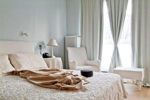 biała sypialnia z łóżkiem, krzesłem i oknem w obiekcie Triton Apartments in Warsaw w Warszawie