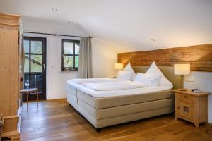 een slaapkamer met een groot wit bed met witte kussens bij Chalet Vierjahreszeiten in Garmisch-Partenkirchen