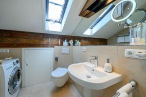 een badkamer met wastafel en wasmachine bij Chalet Vierjahreszeiten in Garmisch-Partenkirchen +29 foto's