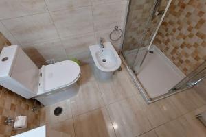La salle de bains est pourvue de toilettes, d'un lavabo et d'une douche. dans l'établissement Enjoy Lisbon Cascais Sintra 1200 metres to metro blue line Sintra Rail line Free Parking, à Amadora