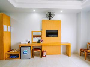 een kamer met een bureau, een tafel en een televisie bij UFJ HOTEL Sầm Sơn in Sầm Sơn