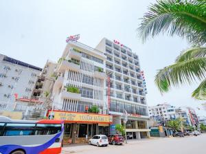 Przed dużym budynkiem stoi autobus w obiekcie UFJ HOTEL Sầm Sơn w mieście Sam Son