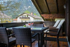 een tafel en stoelen op een balkon met wijnglazen bij Chalet Vierjahreszeiten in Garmisch-Partenkirchen
