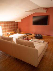 een woonkamer met een bank en een flatscreen-tv bij Chambre Flori - Lavy in Saint-Pierre-de-Côle