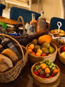 un tavolo ricoperto di cesti di frutta e pane di Chambre Flori - Lavy a Saint-Pierre-de-Côle