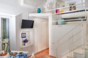 Habitación con escalera y TV en la pared. en Casa Giulia en Capri