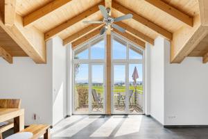 un soggiorno con ventilatore a soffitto e una grande finestra di Cosy Home Allgäu - modern und gemütlich a Haldenwang