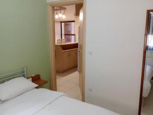 1 Schlafzimmer mit einem weißen Bett und einem Badezimmer in der Unterkunft Elpida's houses 1 Private parking Near city centre in Thessaloniki