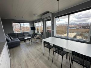 Il comprend une cuisine et un salon avec une table et des chaises. dans l'établissement Cabin in Faukás, west part of Iceland - Birta Rentals, à Fossatún