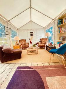 a living room with couches and chairs in a tent at The Spot - 200m de la Plage in Saint-Hilaire-de-Riez