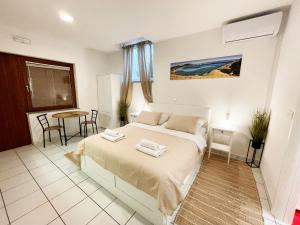 a bedroom with a bed and a table and chairs at Basement Studio Bed&Breakfast in Punat