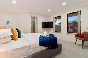a bedroom with a large bed and a tv at Sandy Retreat Your Perfect Beach Getaway in Silversands in Mandurah