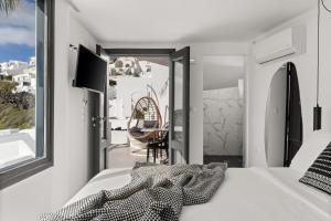 a bedroom with a bed and a view of a balcony at Mill Houses New Elegant Suites in Firostefani