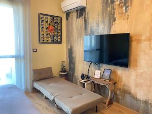 un soggiorno con una grande TV a schermo piatto a parete di [3' a piedi dal mare] CASITA DEL MAR...Mare & Arte a Grottammare